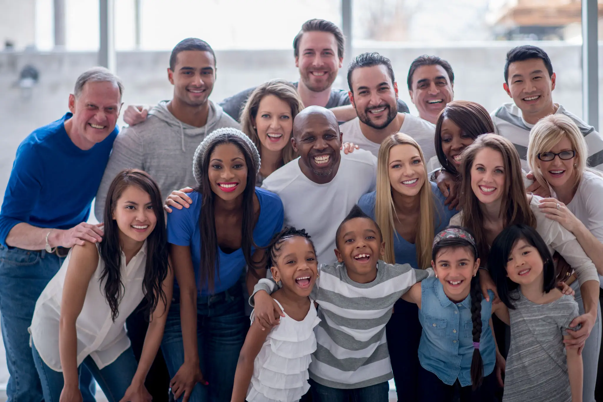 Diverse group of smiling people posing together outdoors.