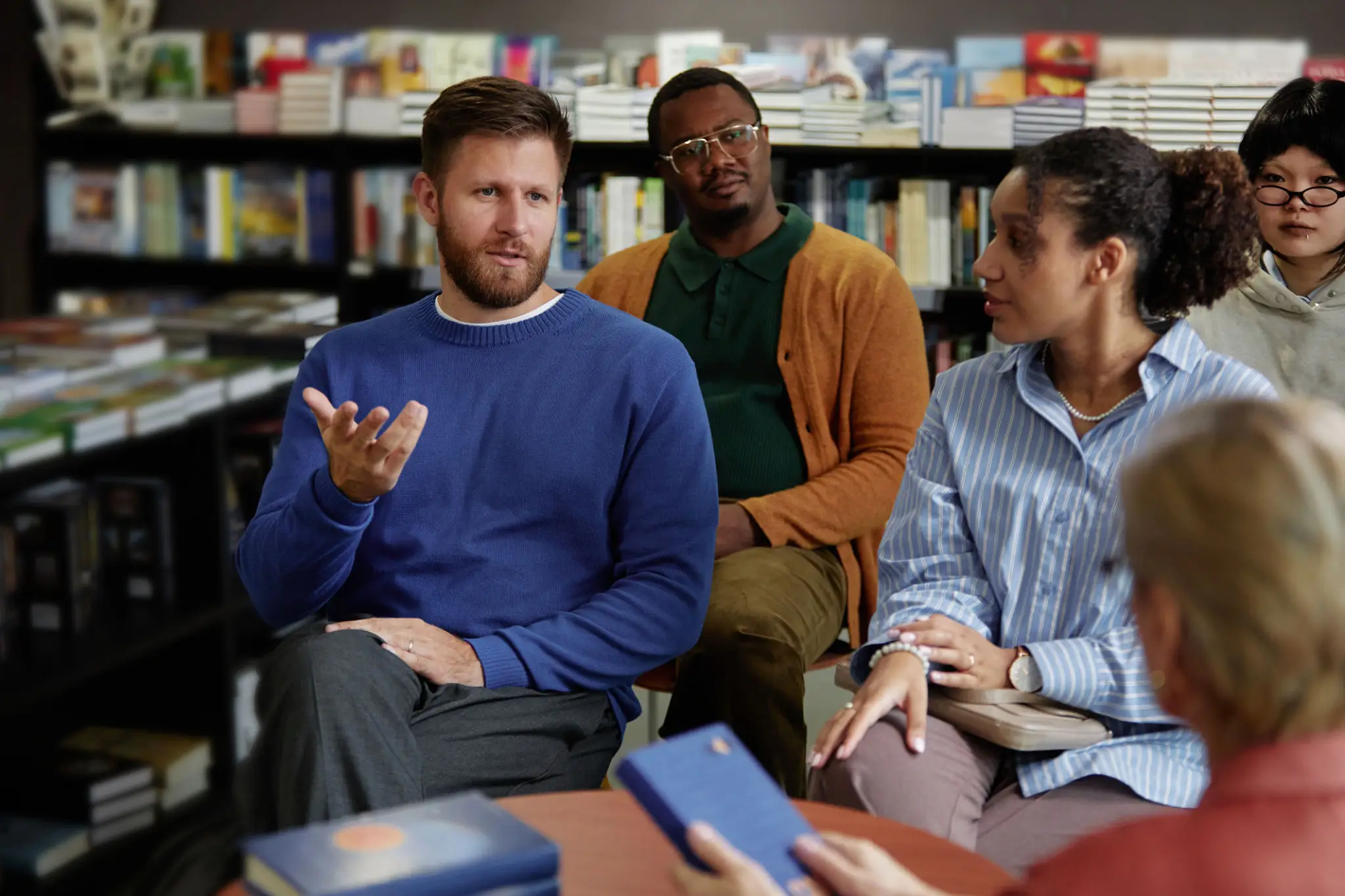 Three coworkers engaged in a discussion during a meeting.